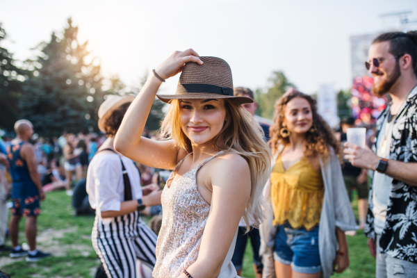 Group of cheerful young friends at summer festival, looking at camera.