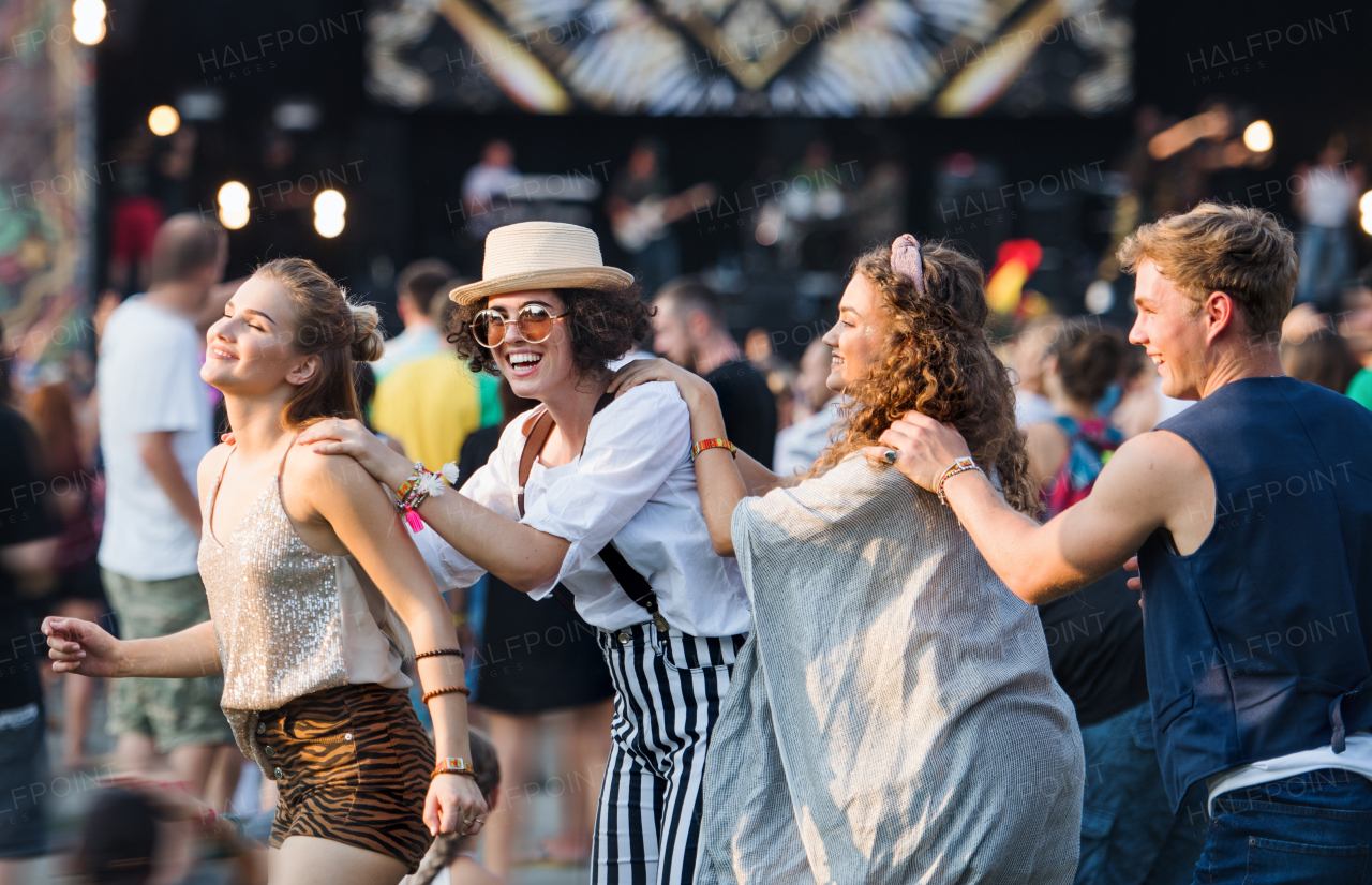 Group of cheerful young friends at summer festival, having fun.