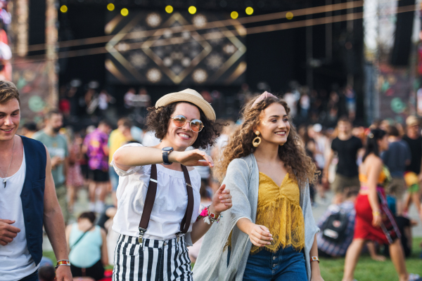 A front view portrait of group of young friends dancing at summer festival.