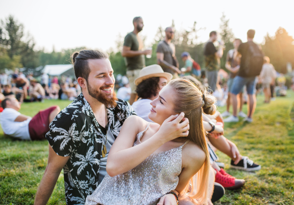 A young couple in love at summer festival, talking.