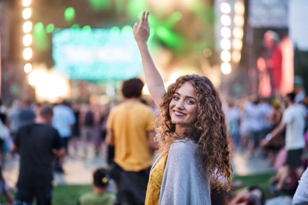 Beautiful young woman with friends dancing at summer festival.