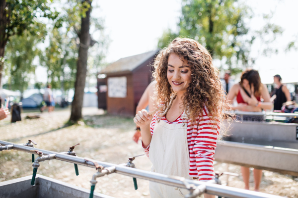 Beautiful young woman with tootbrush at summer festival, washing in the morning.