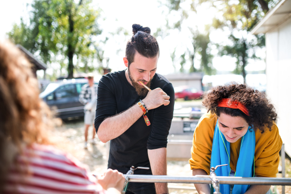 A group of young friends at summer festival, washing in the morning.