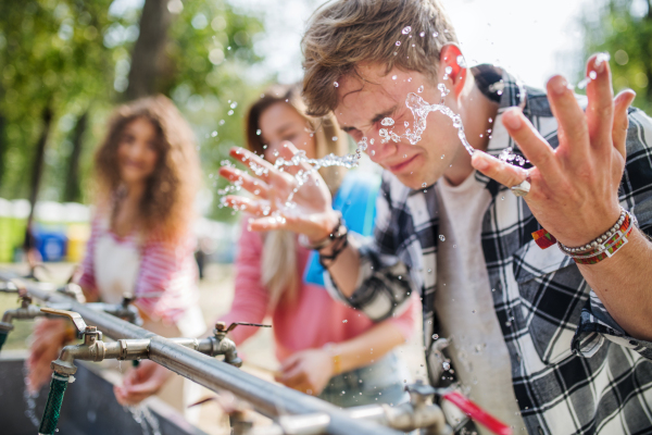 A group of young friends at summer festival, washing in the morning.