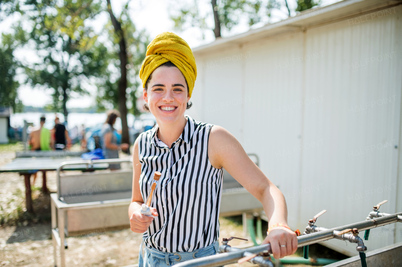 Young woman at summer festival, washing in the morning by basins.