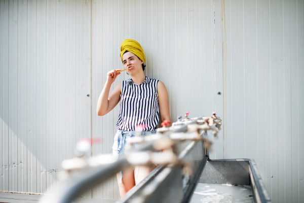 Front view of young woman at summer festival, brushing teeth by basins.