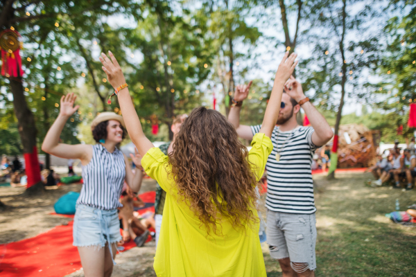 Group of young cheerful friends dancing at summer festival.