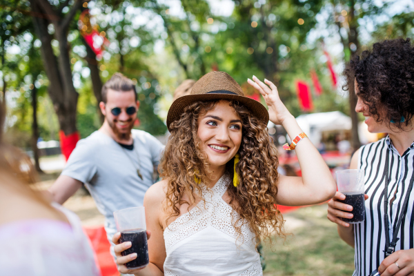 Group of cheerful young friends at summer festival, having fun.