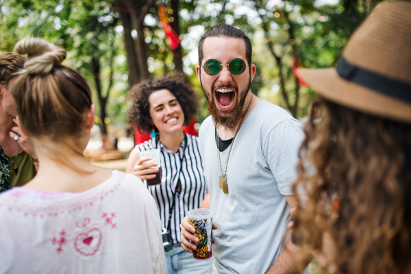 Group of cheerful young friends at summer festival, having good time.