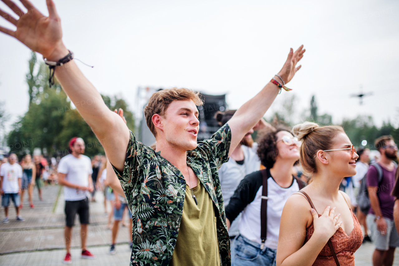 Group of cheerful young friends at summer festival, dancing.