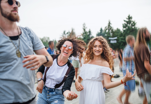 Group of cheerful young friends at summer festival, having fun.