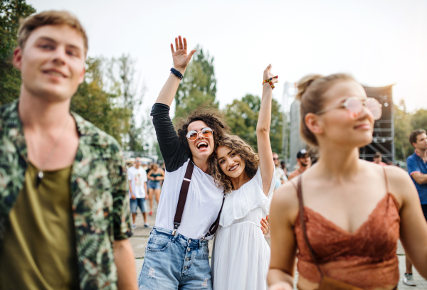 A front view portrait of group of young friends dancing at summer festival.