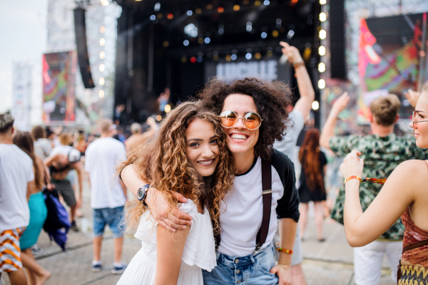 Young girl friends at summer festival, posing for photograph. Copy space.