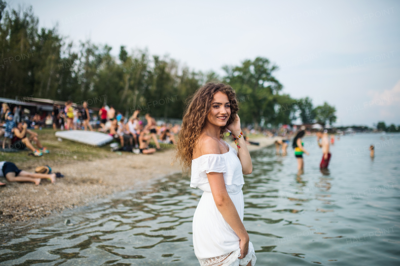 Young woman at summer festival, standing in lake. Copy space.