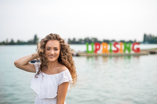 Young woman at summer festival, standing in lake. Copy space.