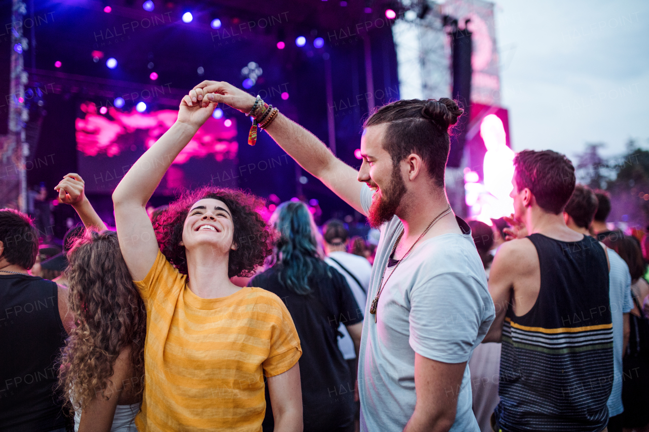 A young couple dancing at summer festival in the evening.