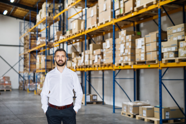 Portrait of a male warehouse worker or a supervisor, hands in pockets.