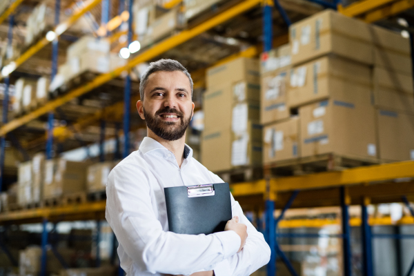 Portrait of a male warehouse worker or a supervisor holding notes.