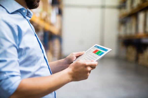 Unrecognizable man warehouse worker with a tablet.