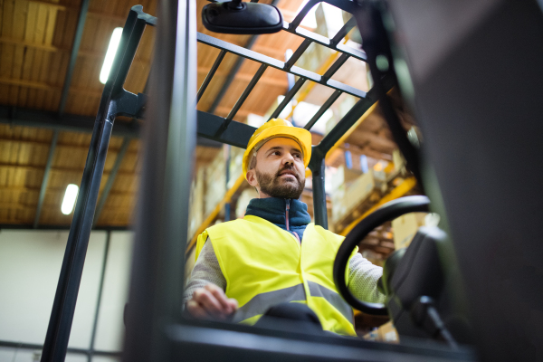 Man forklift driver working in a warehouse.