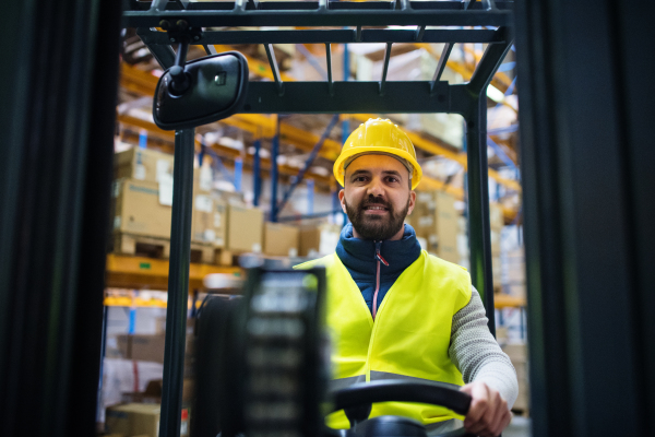 Man forklift driver working in a warehouse.