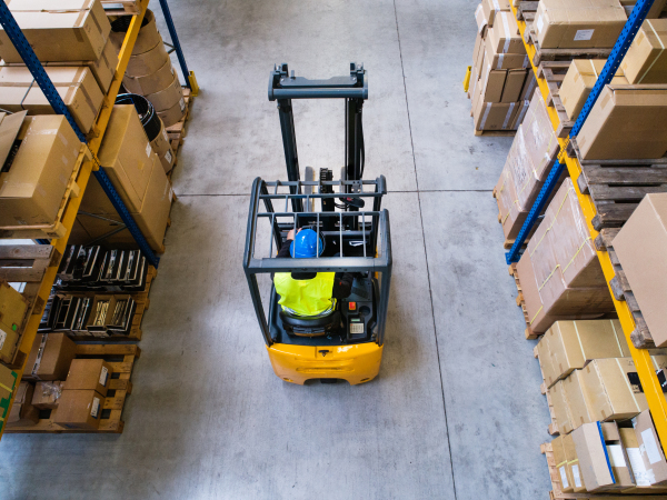 Man forklift driver working in a warehouse. Aerial view.