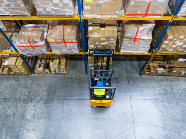 Man forklift driver working in a warehouse. Aerial view.