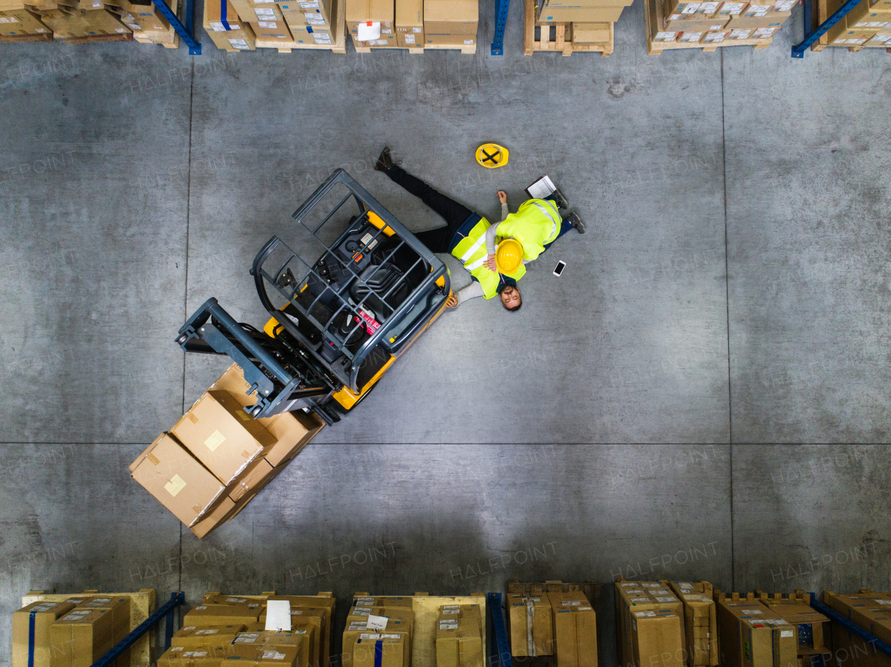 An accident in a warehouse. Woman performing cardiopulmonary resuscitation. Aerial view.