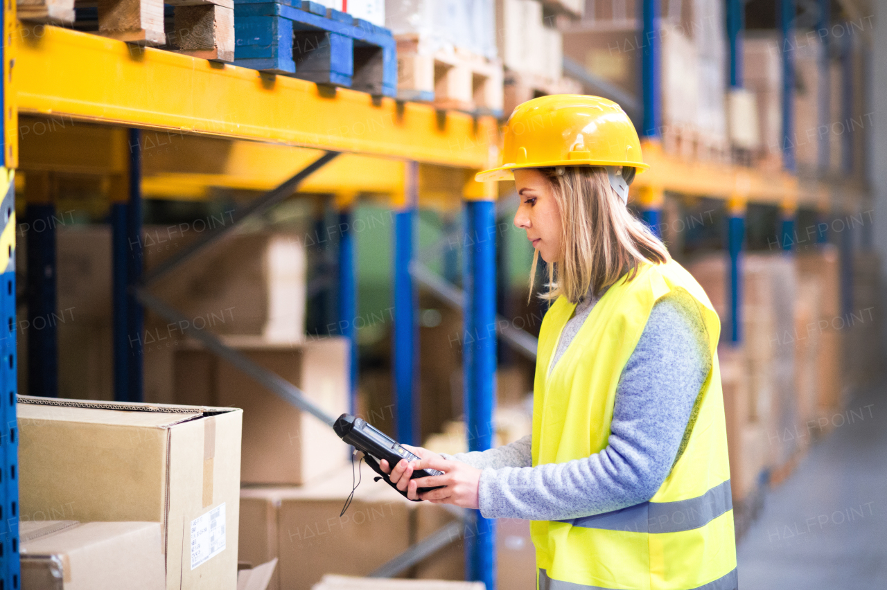 Warehouse woman worker or supervisor with barcode scanner. A mobile handheld PC with barcode scanner.