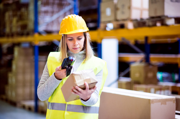 Warehouse woman worker or supervisor with barcode scanner. A mobile handheld PC with barcode scanner.