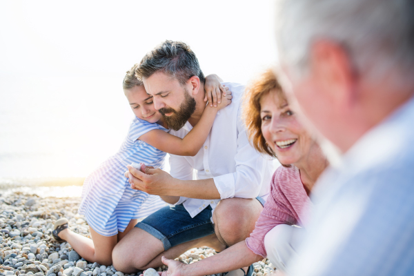 A multigeneration family on a holiday sitting by the lake, talking.