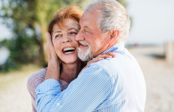 A close-up of senior couple on a holiday on a walk, hugging.