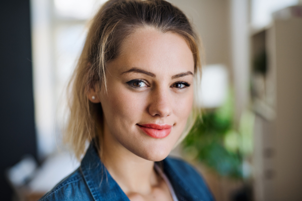 A close-up portrait of happy young woman indoors at home.