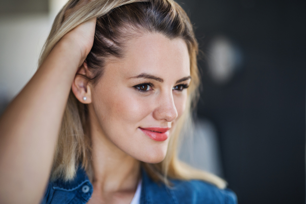 A close-up portrait of happy young woman indoors at home.