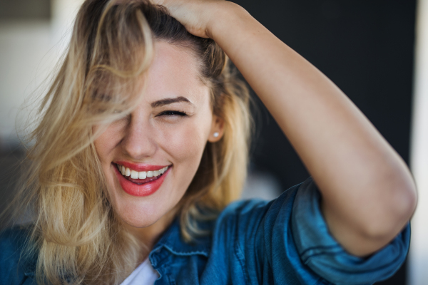 A close-up portrait of cheerful young woman indoors at home.