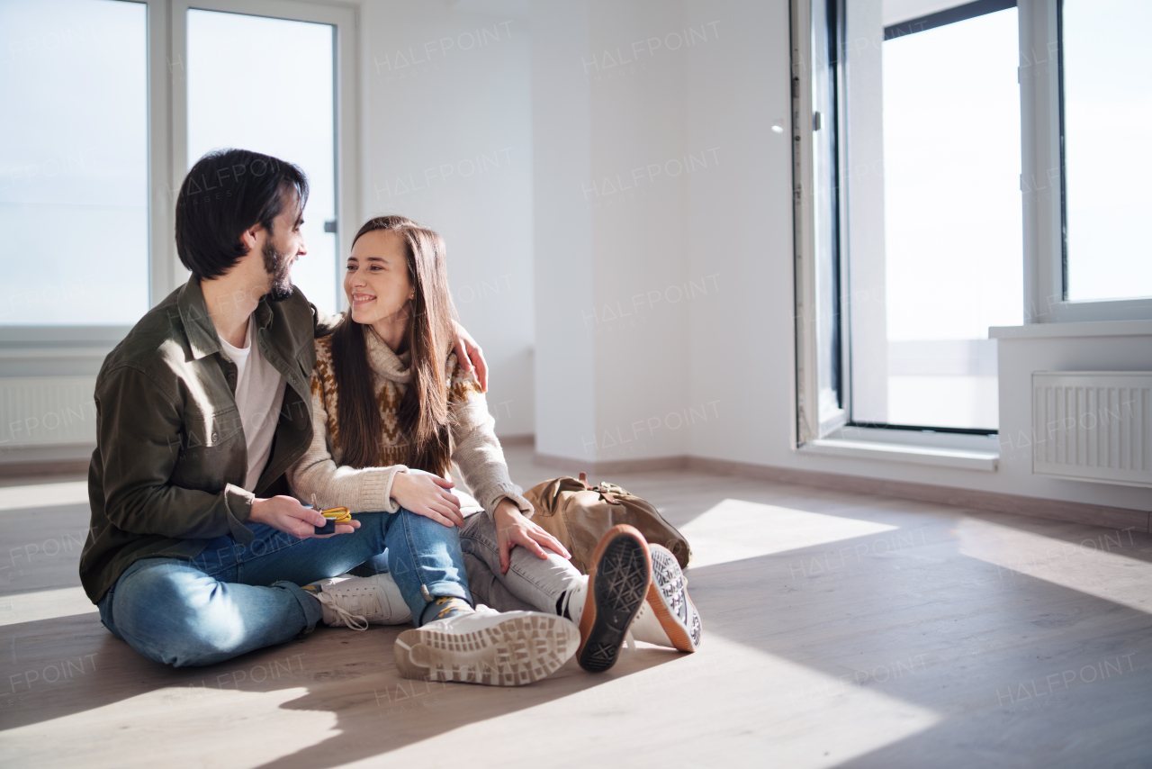 Happy young couple with keys moving in new flat, new home and relocation concept.