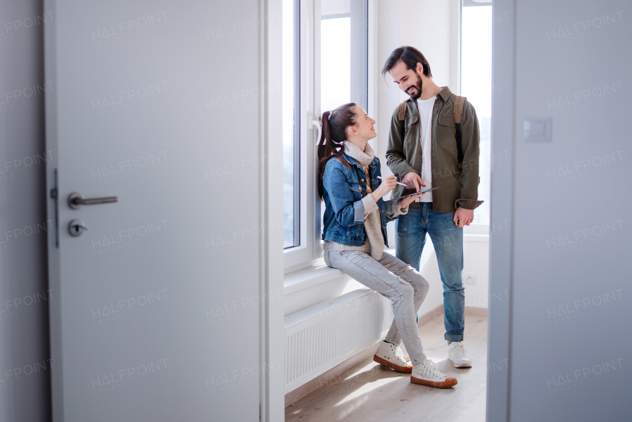 Happy young couple with tablet moving in new flat, new home and relocation concept.