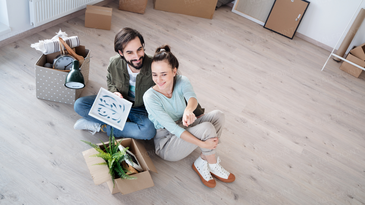 Top view of happy young couple moving in new flat, new home and relocation concept.