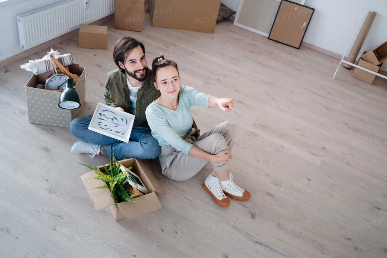 Happy young couple with boxes moving in new flat, new home and relocation concept.