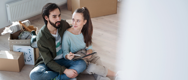 Top view of happy young couple moving in new flat, new home and relocation concept.