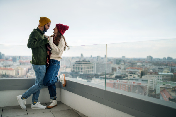 Happy young couple owners with coffee on balcony in new flat, moving in, new home and relocation concept.