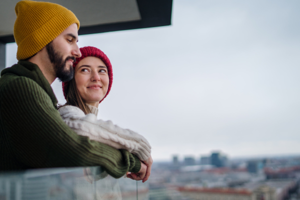 Happy young couple owners on balcony in new flat, moving in, new home and relocation concept.