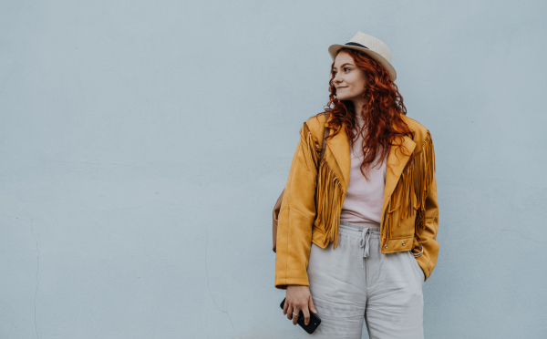 A young woman tourist outdoors against white background on trip in town, looking aside.