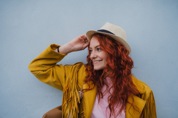 A young woman tourist outdoors against white background on trip in town, looking aside.