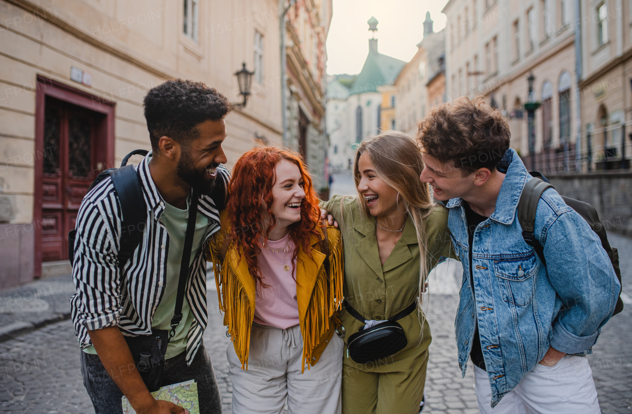 A front view of group of happy young people outdoors on street on town trip, having fun.