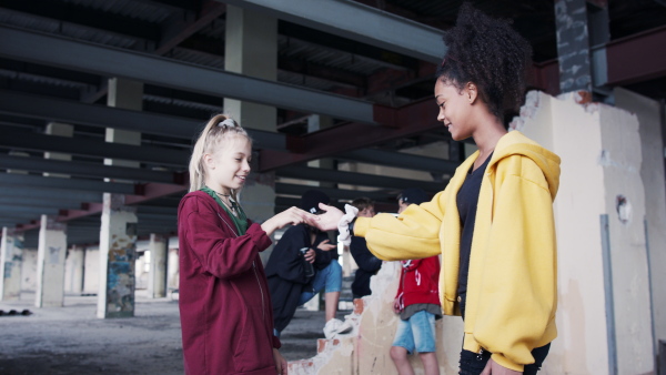 Group of boys and girls teenagers gang greeting indoors in abandoned building.