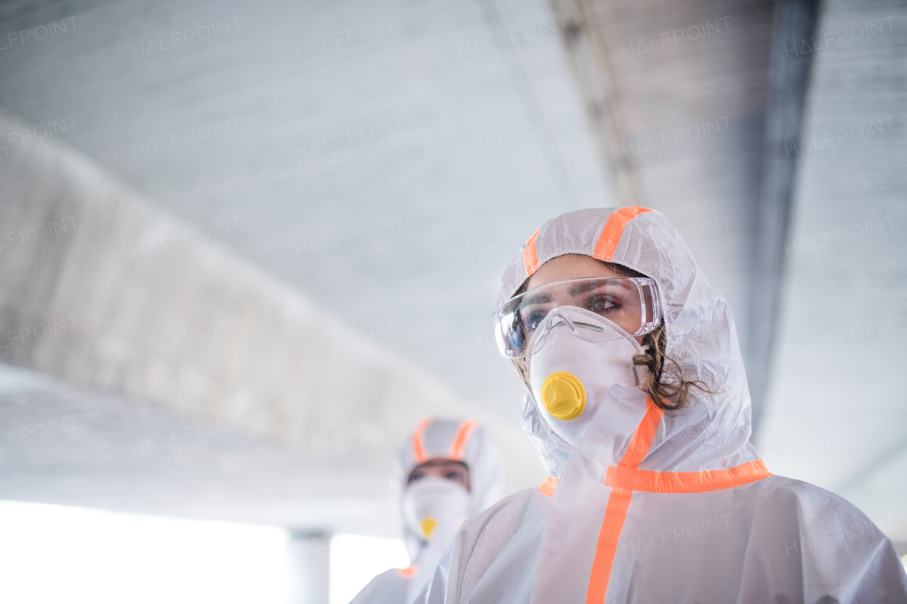 People with masks and protective suits walking outdoors, coronavirus concept.