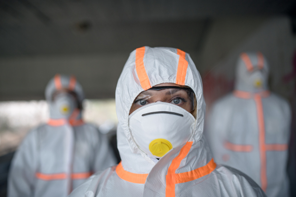 People with protective suits and mask respirators outdoors, coronavirus concept.