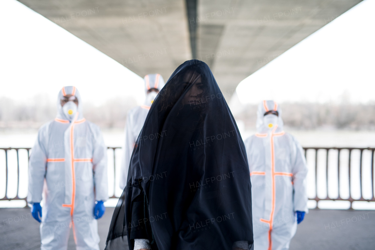 People with protective suits and respirators outdoors, coronavirus and death concept.