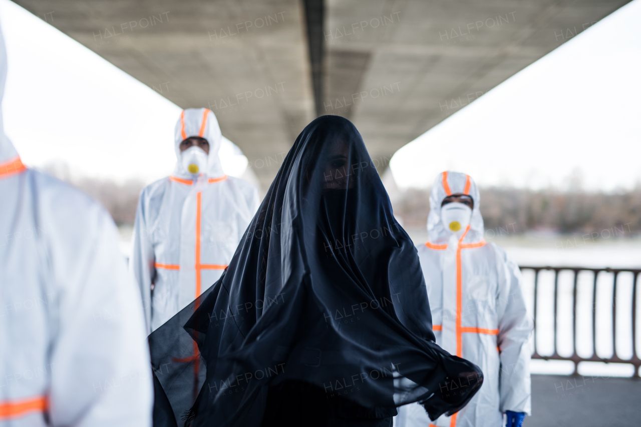 People with protective suits and respirators outdoors, coronavirus and death concept.